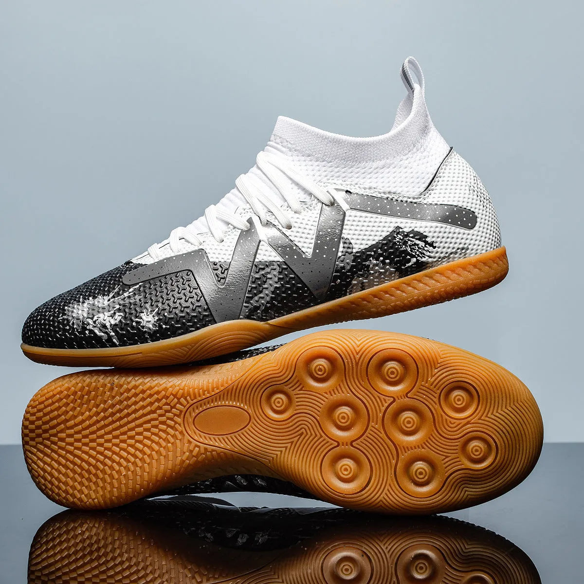 Low-top black and yellow football trainers with removable screw-in studs on the sole.
