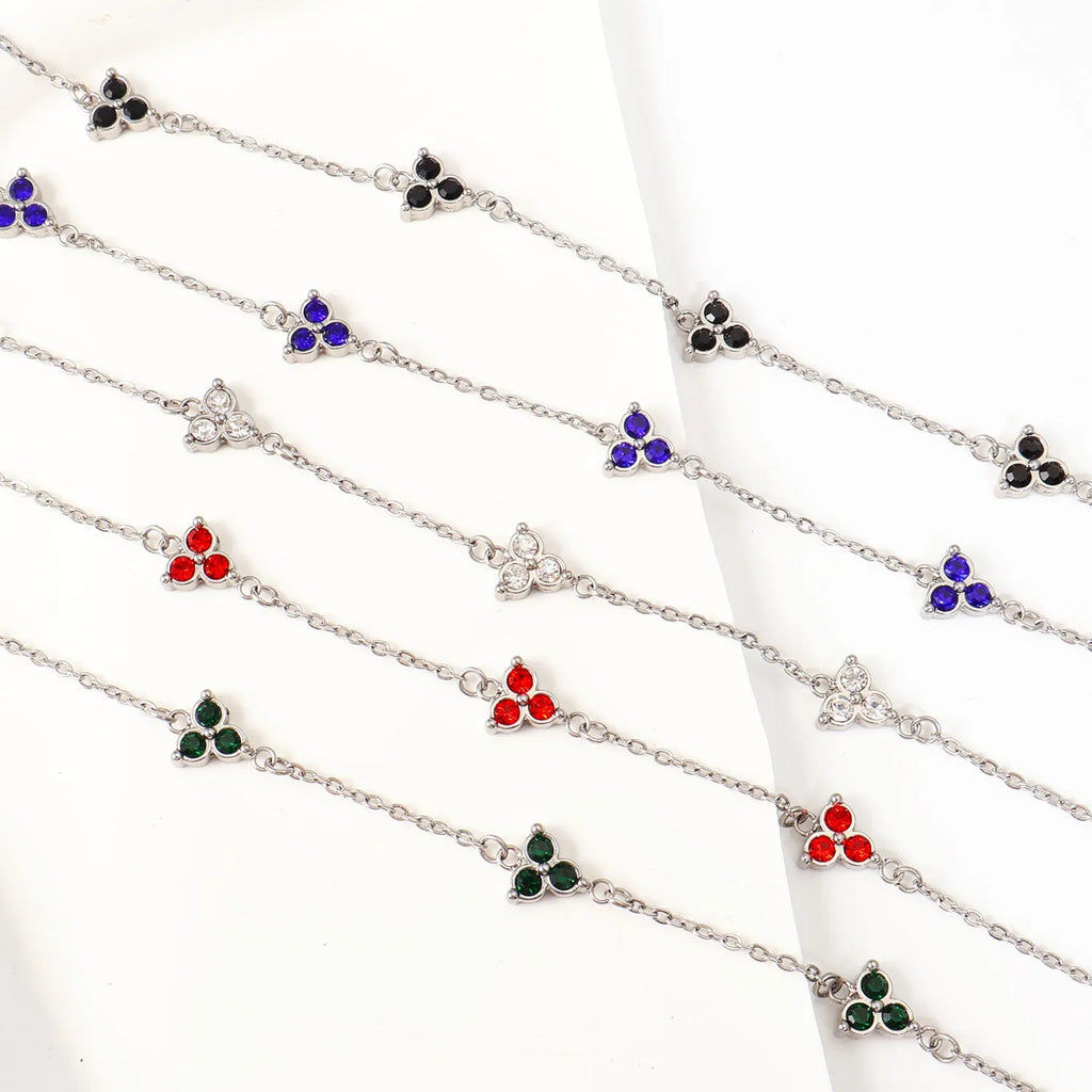 Women's stainless steel geometric bracelet with triangle design and three-diamond centrepiece in gold or steel finish.
