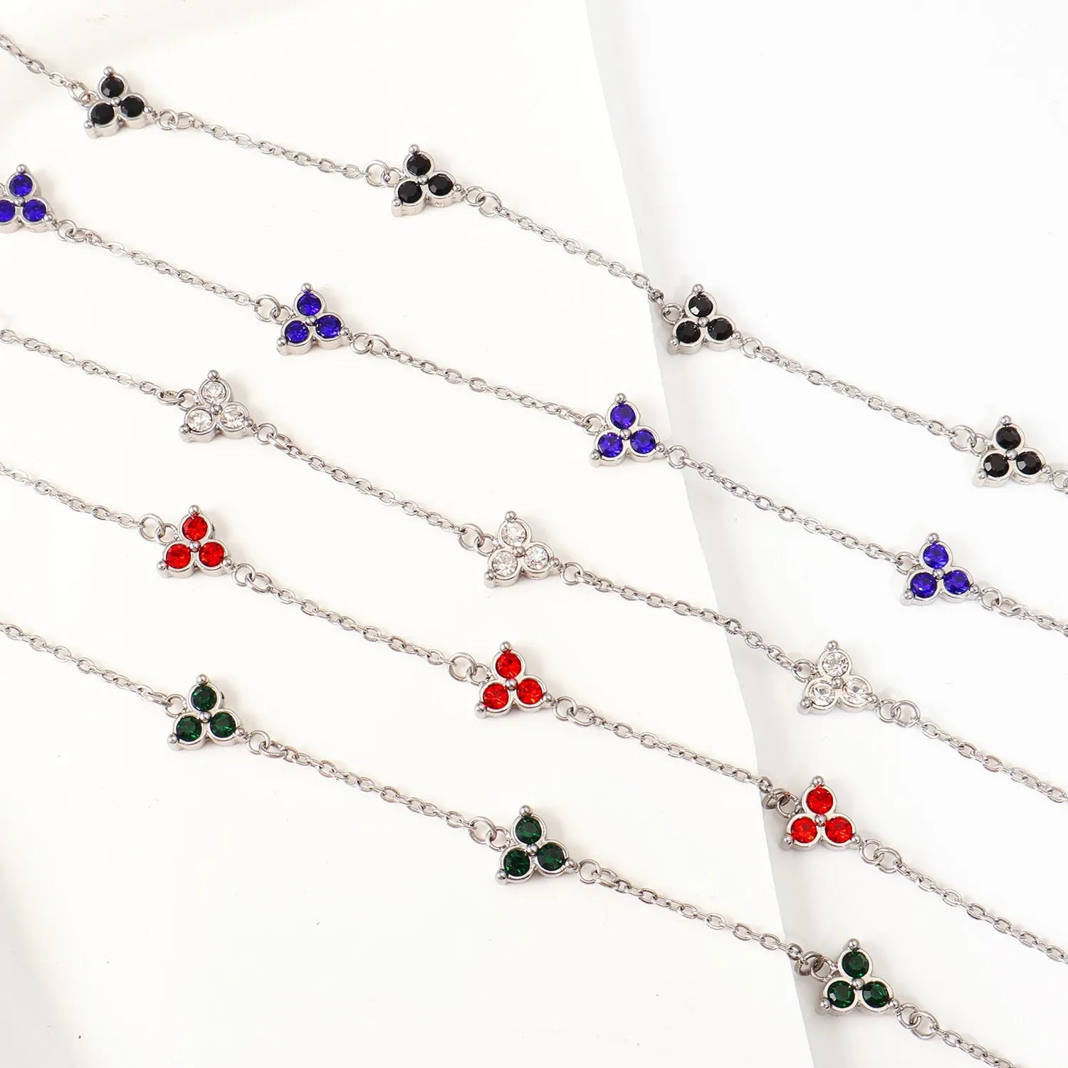 Women's stainless steel geometric bracelet with triangle design and three-diamond centrepiece in gold or steel finish.