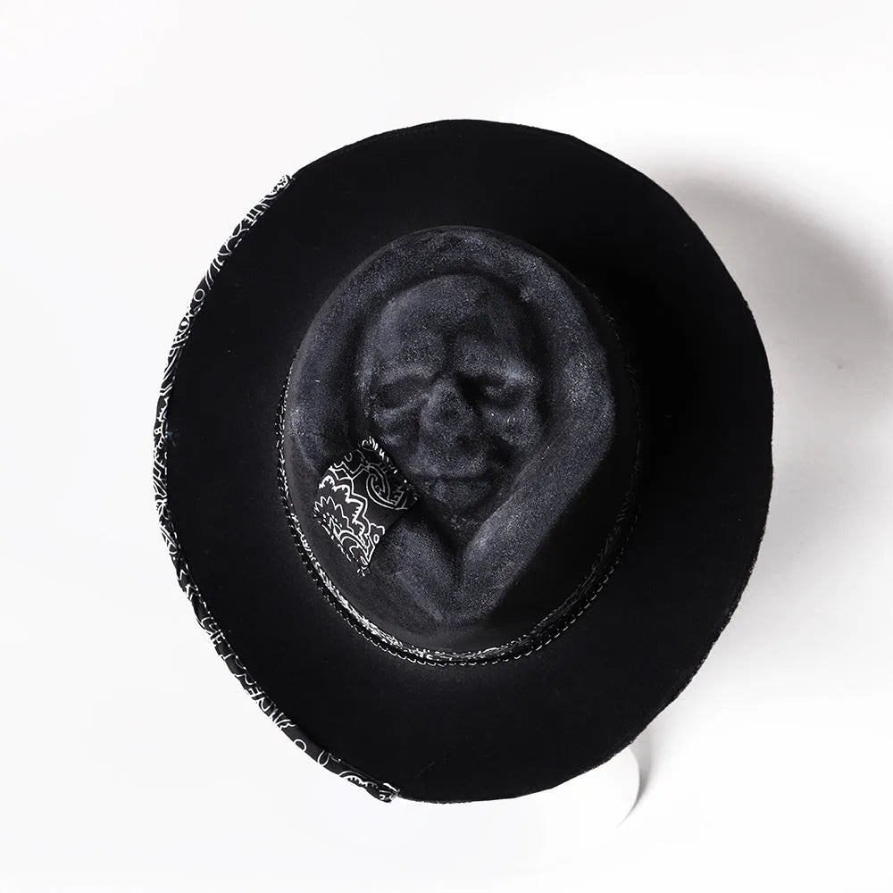 Handmade black skull hat with conical crown, made from wool and denim fabric, on a neutral background.