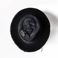 Handmade black skull hat with conical crown, made from wool and denim fabric, on a neutral background.