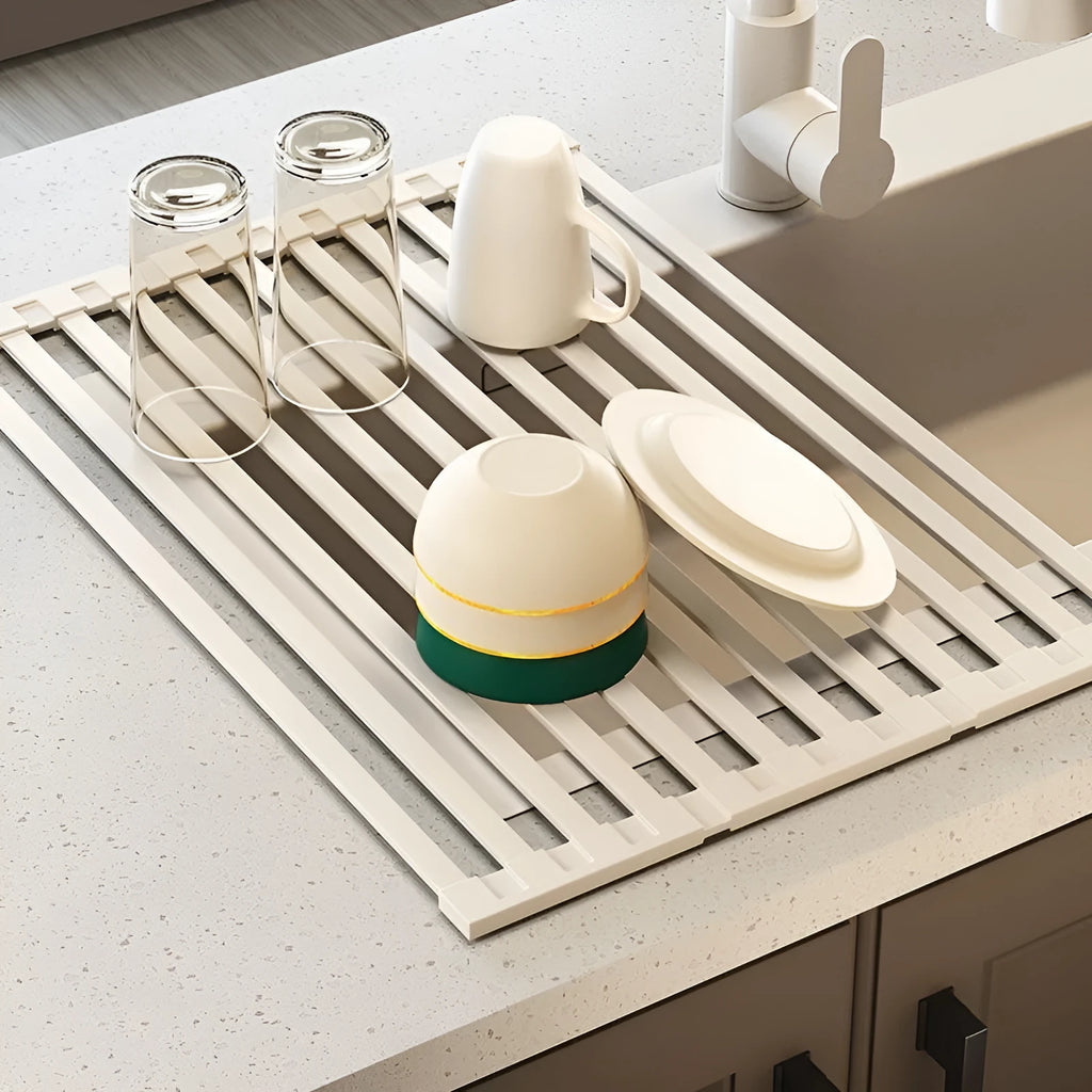 Milky white foldable stainless steel kitchen draining rack shown in a sink.