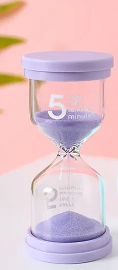 Handmade glass sand timer hourglass in blue on a plain background.