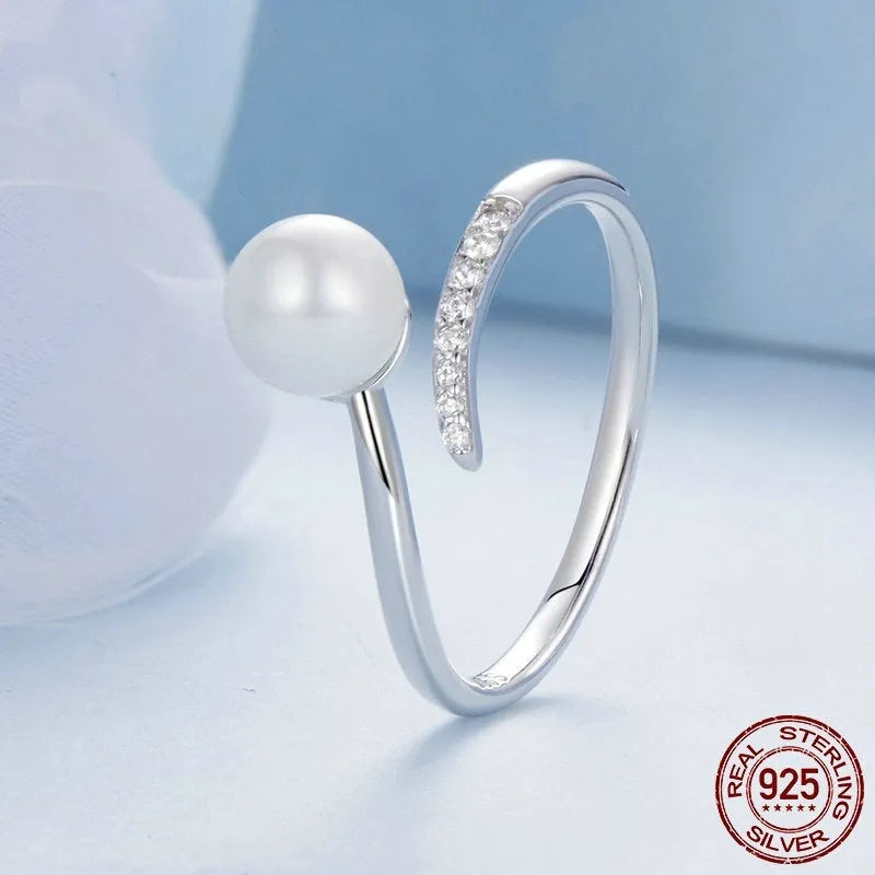 S925 sterling silver adjustable ring with a natural shell pearl on an open loop band.