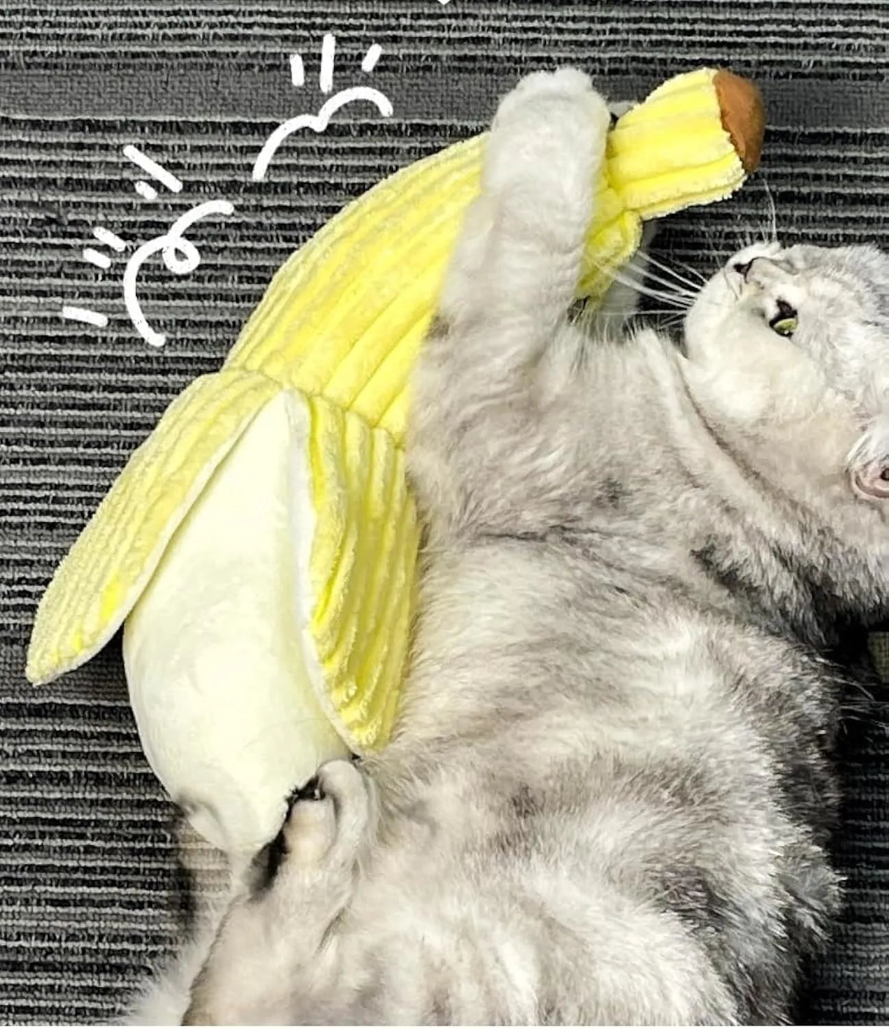 Yellow banana-shaped plush cat toy with a textured velvet strip, shown next to a cat for scale.