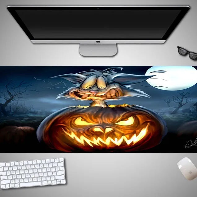 Oversized Halloween graphic cloth mouse pad on a desk, showing non-slip rubber base.