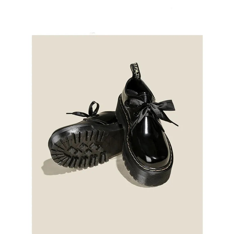 Women's black leather shoes with thick soles, ribbon cross straps, and lacing closure