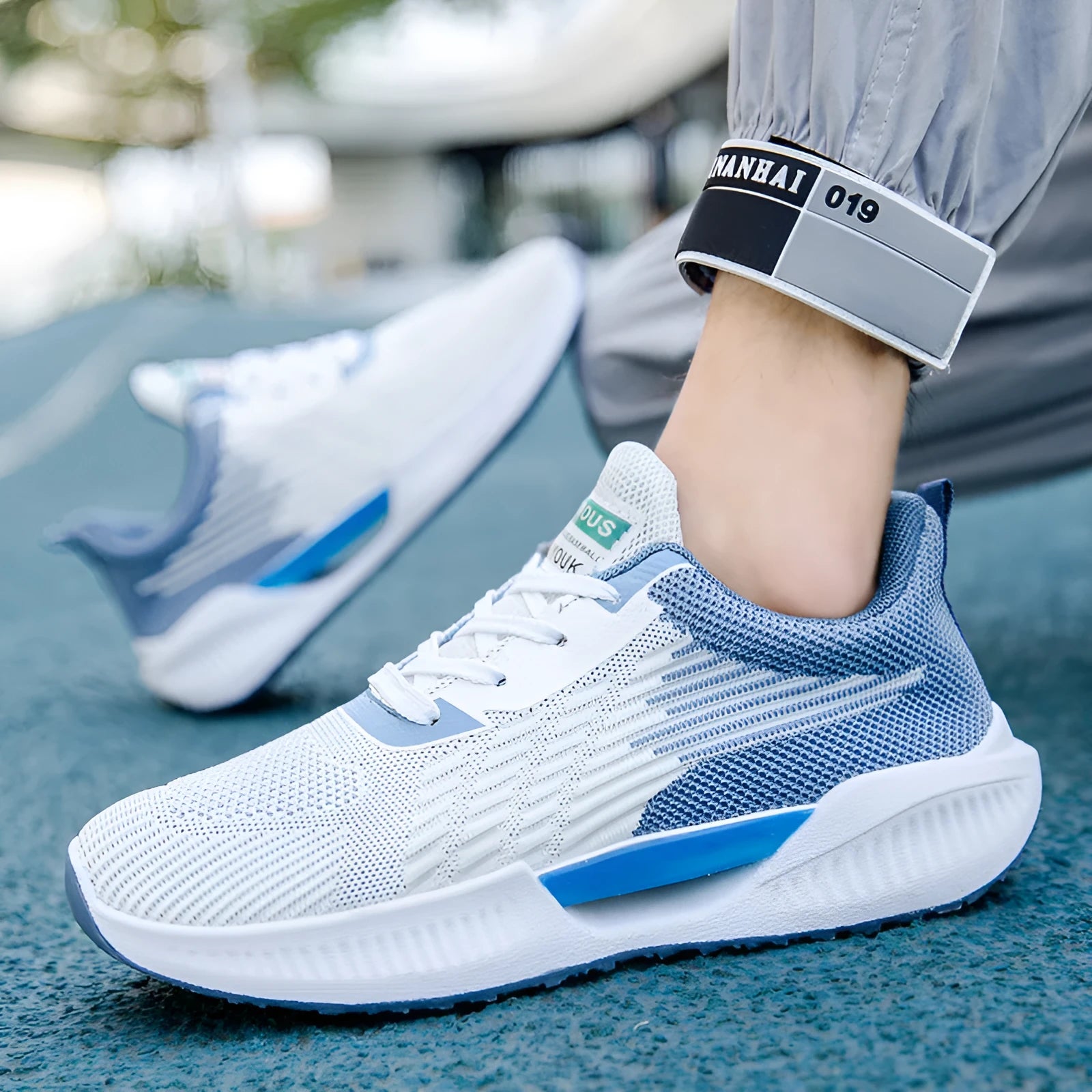 Men's blue breathable casual sports shoe with cloth upper and plastic sole on a white background.