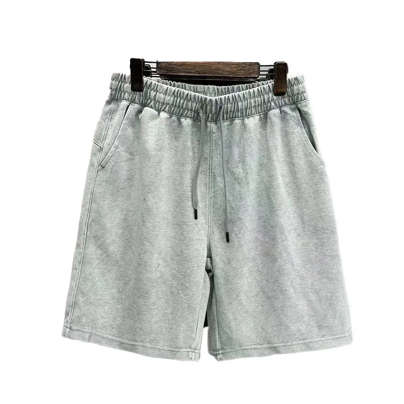 Men's solid colour distressed cotton shorts in a loose straight-leg casual fit.