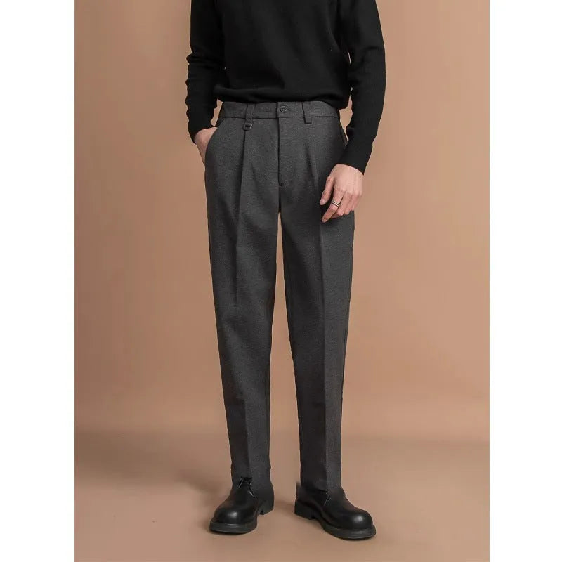 Man wearing grey straight leg polyester trousers for a smart casual look.