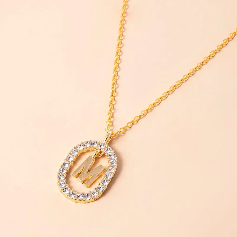 Gold crystal letter initial oval pendant necklace on woman, rhinestone letter in zinc alloy frame with adjustable chain