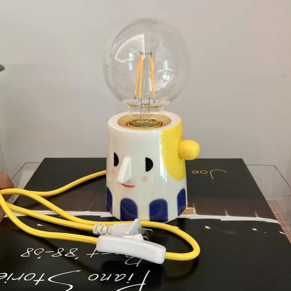Handmade ceramic table lamp with ball headlight design on a bedside table