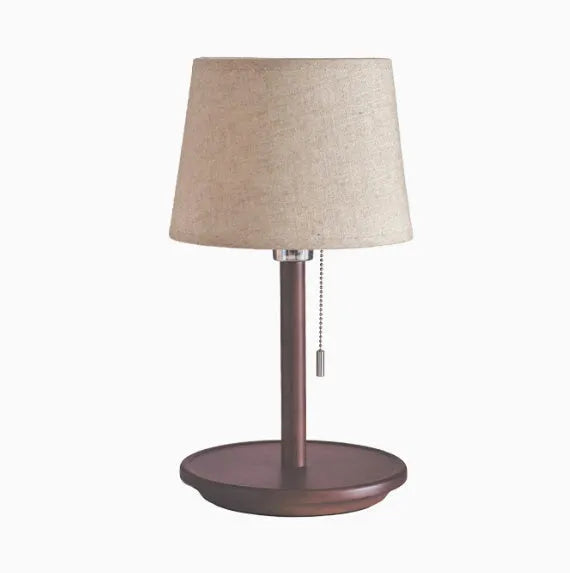 Walnut coloured solid wood bedside table lamp with a white cloth lampshade.