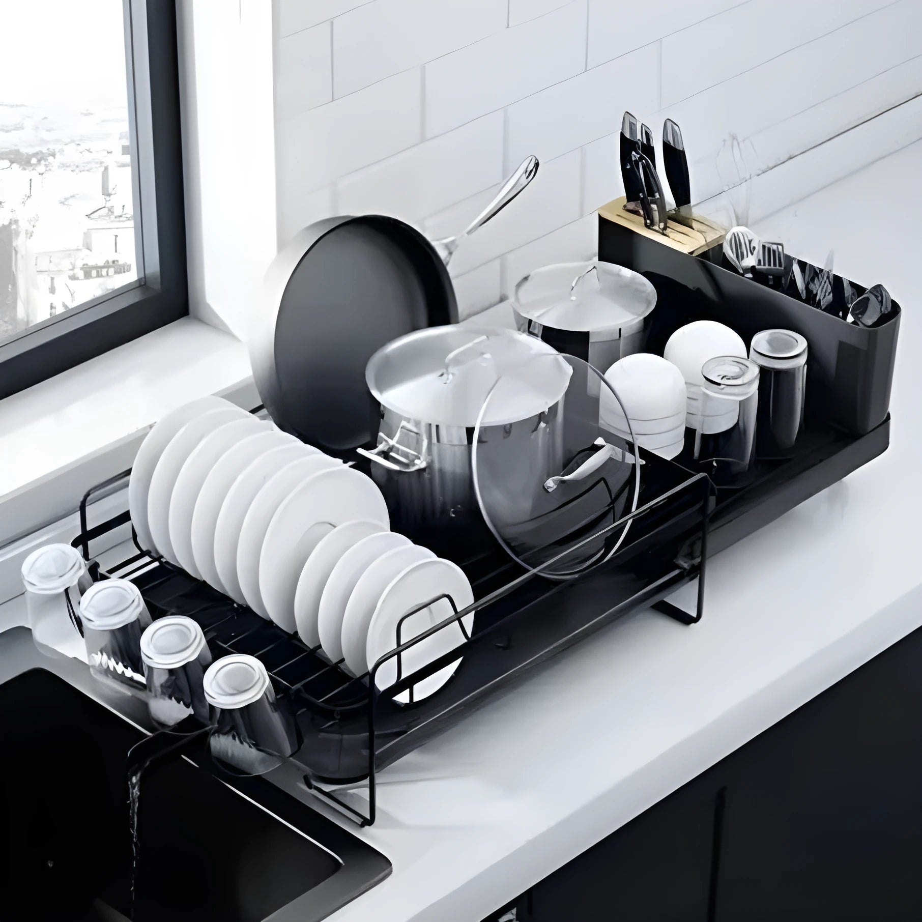 Foldable carbon steel dish drain rack holding cutlery and cups on a kitchen counter.