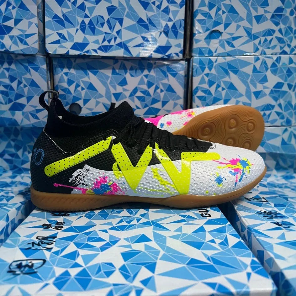 Low-top black and yellow football trainers with removable screw-in studs on the sole.