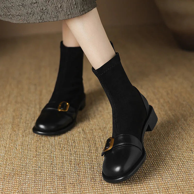 Women's black low heel lace-up Martin ankle boots with belt buckle detail on a white background.
