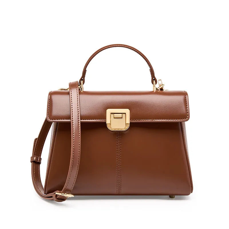 Women's black leather shoulder bag with vachette clasp showing internal compartments and adjustable strap