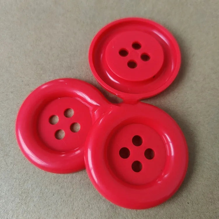 Assortment of oversized round plastic buttons in various colours with four holes.