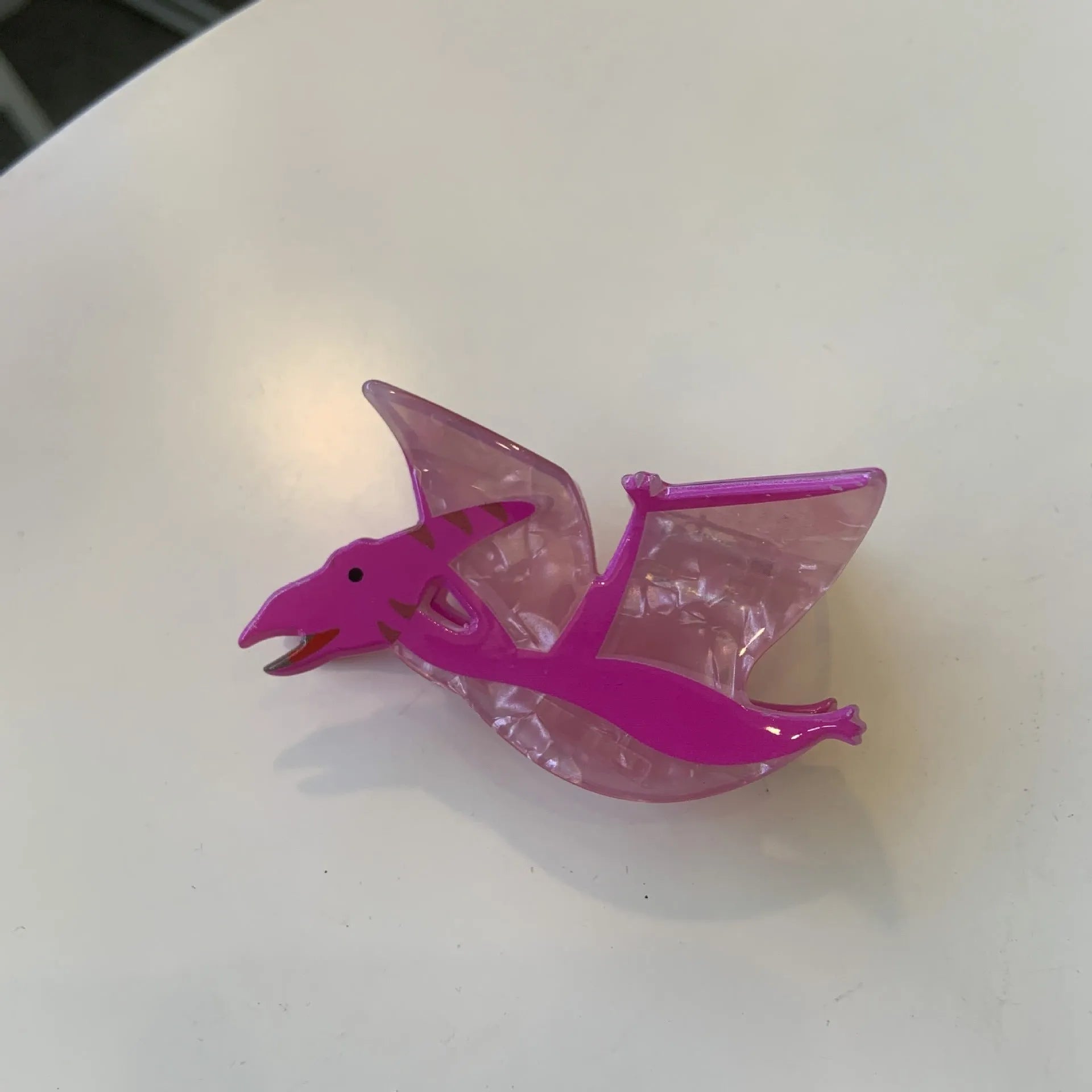 Acrylic hair clip with dinosaur design in various colours including blue, brown, green, pink and purple variants