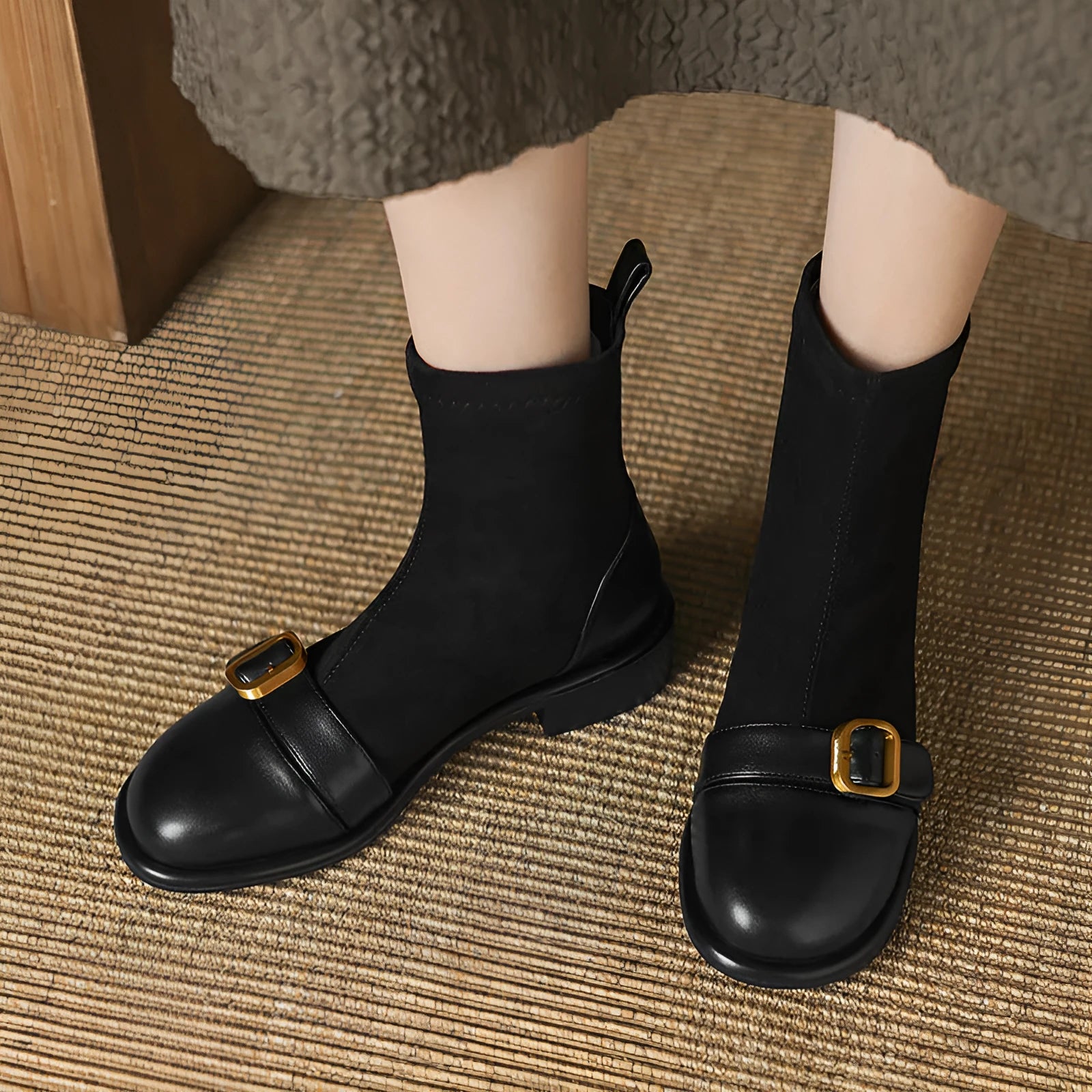 Women's black low heel lace-up Martin ankle boots with belt buckle detail on a white background.