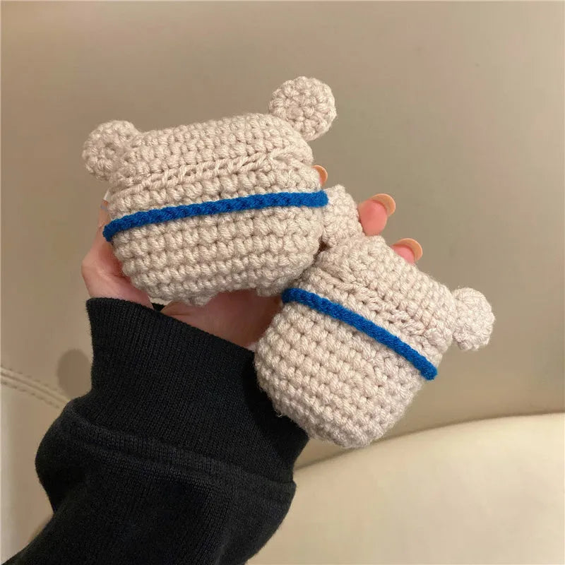 Handmade knitted koala bear backpack cover for Apple Airpods case on a table.