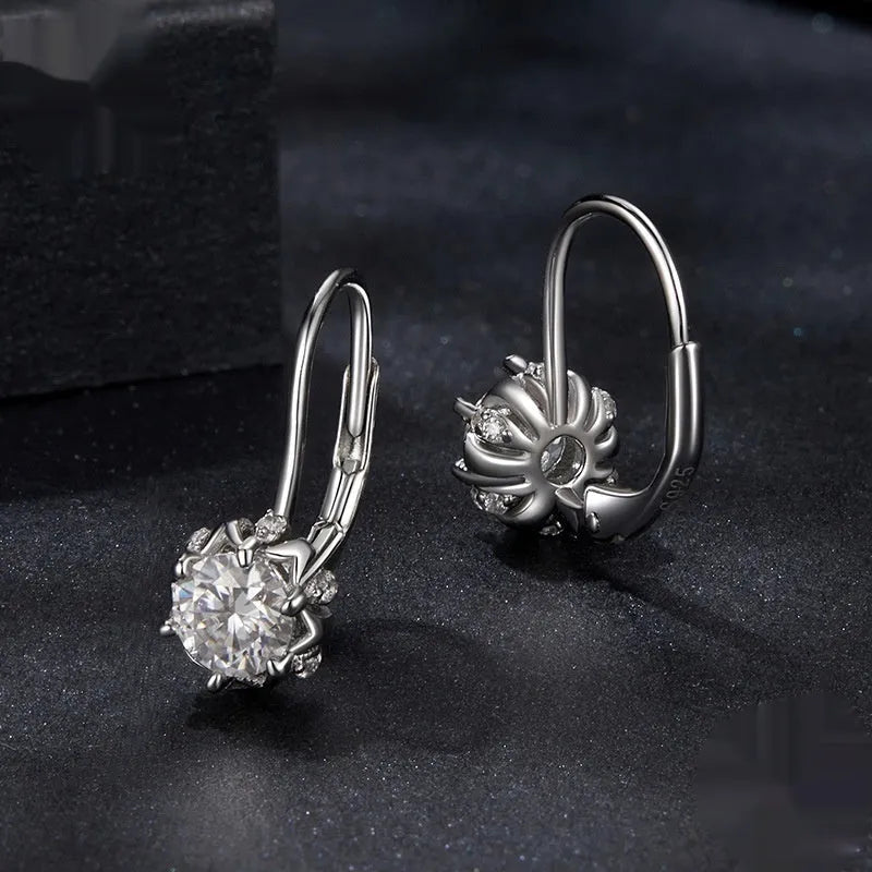 Sterling silver flower bud ear clip with white gold plating and a central moissanite stone.