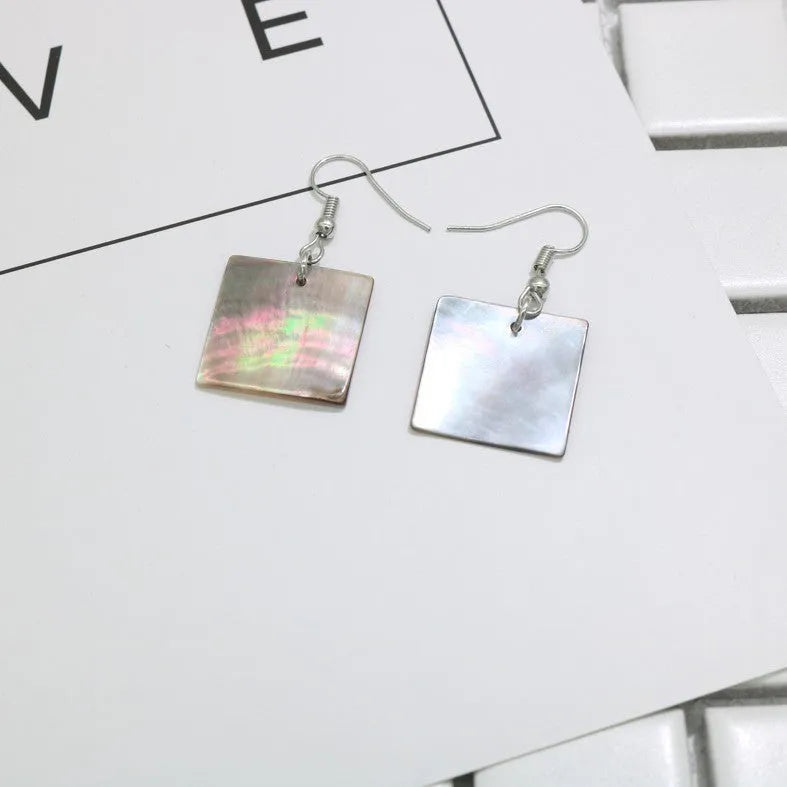 A pair of geometric-shaped earrings made from shell in a retro style, showing colour options.