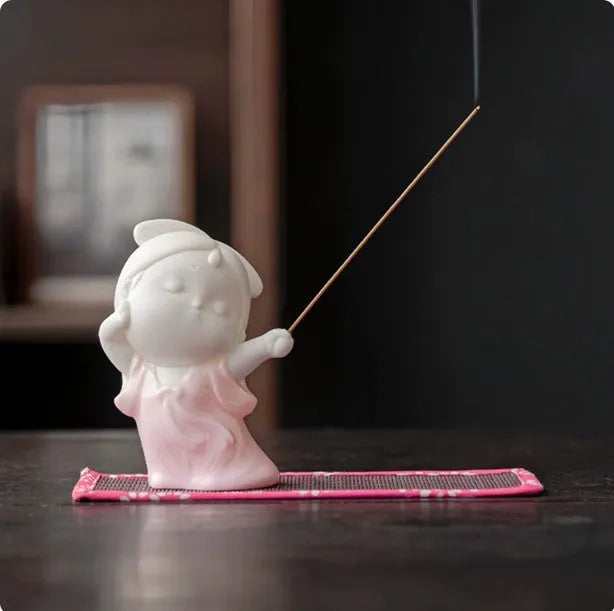 Ceramic cute female court attendant figurine incense burner decoration on a surface.
