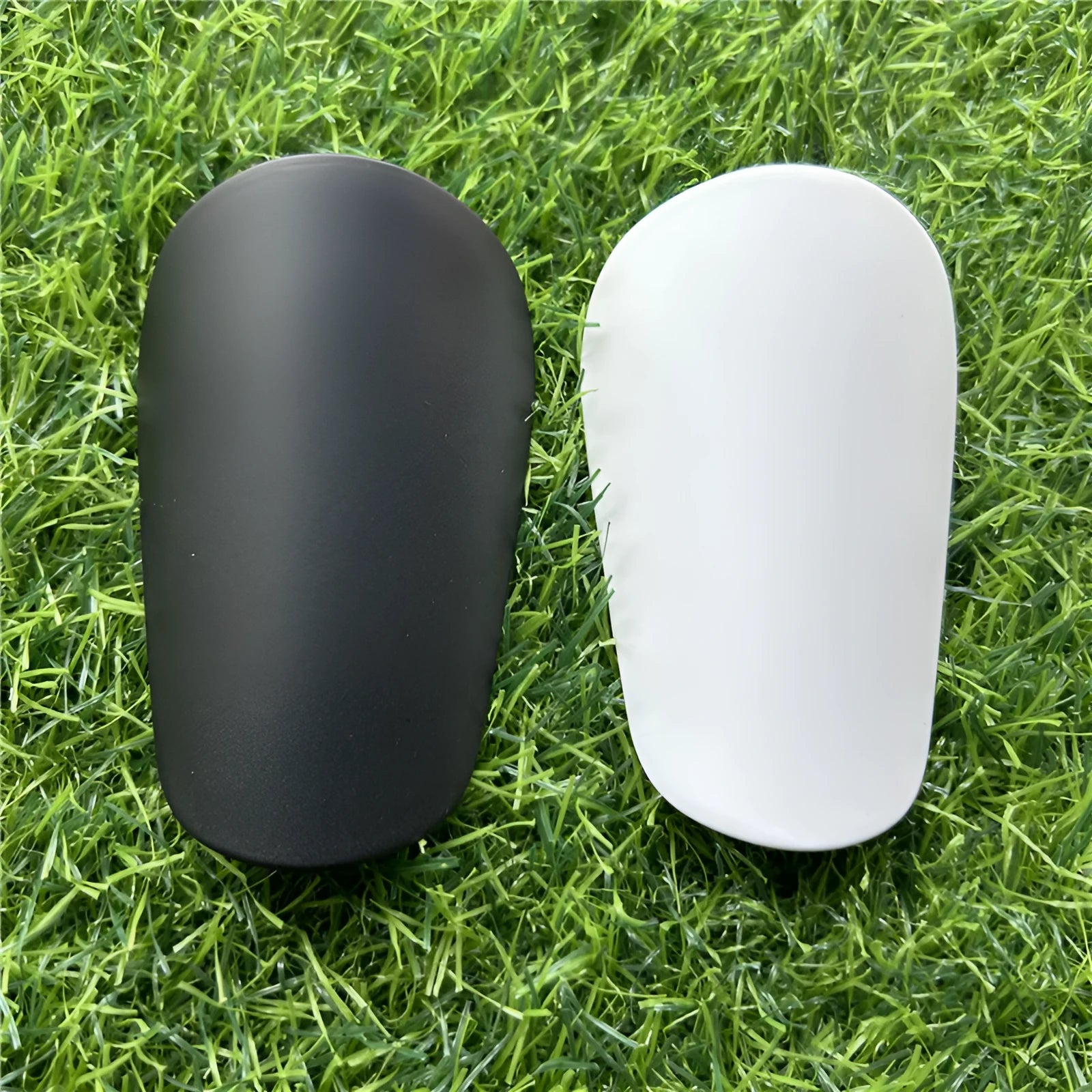 Extra small mini football shin guards measuring 8x5cm in black and white colours