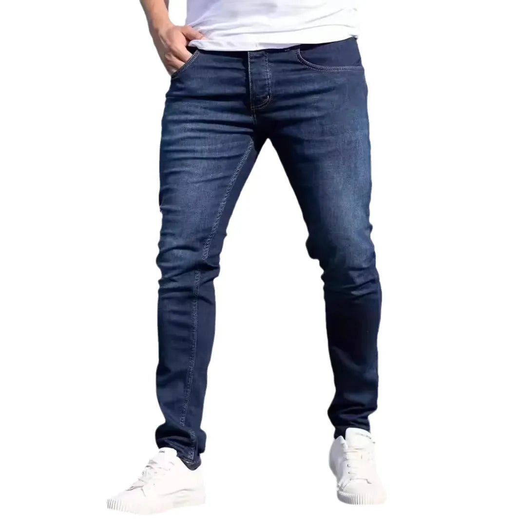 Men's dark blue slim casual jeans with street fashion styling and mid waist design