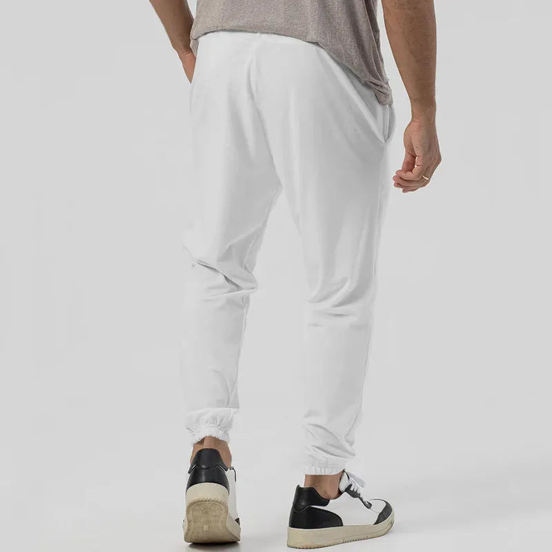 Man wearing gray straight-leg casual track sweatpants with a tapered fit and elastic waistband.