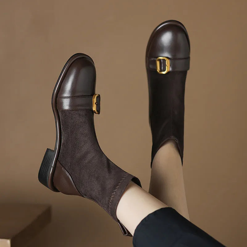 Women's black low heel lace-up Martin ankle boots with belt buckle detail on a white background.