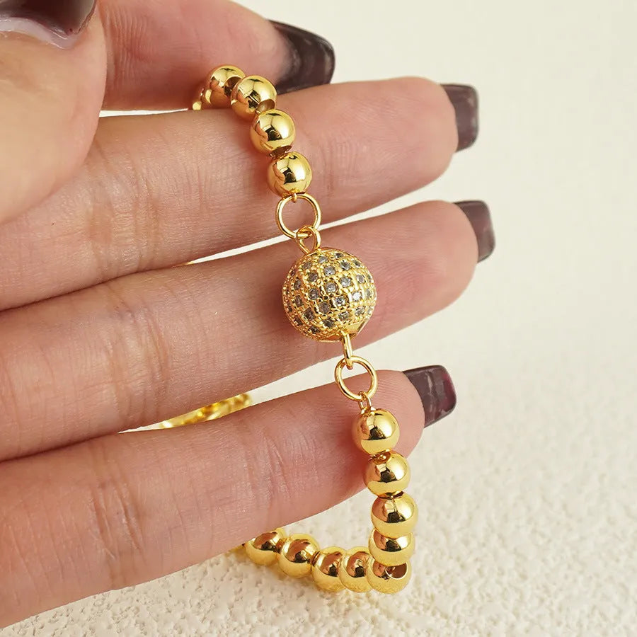 Close-up of a women's copper bracelet with a heart-shaped centre holding a single round zircon stone.