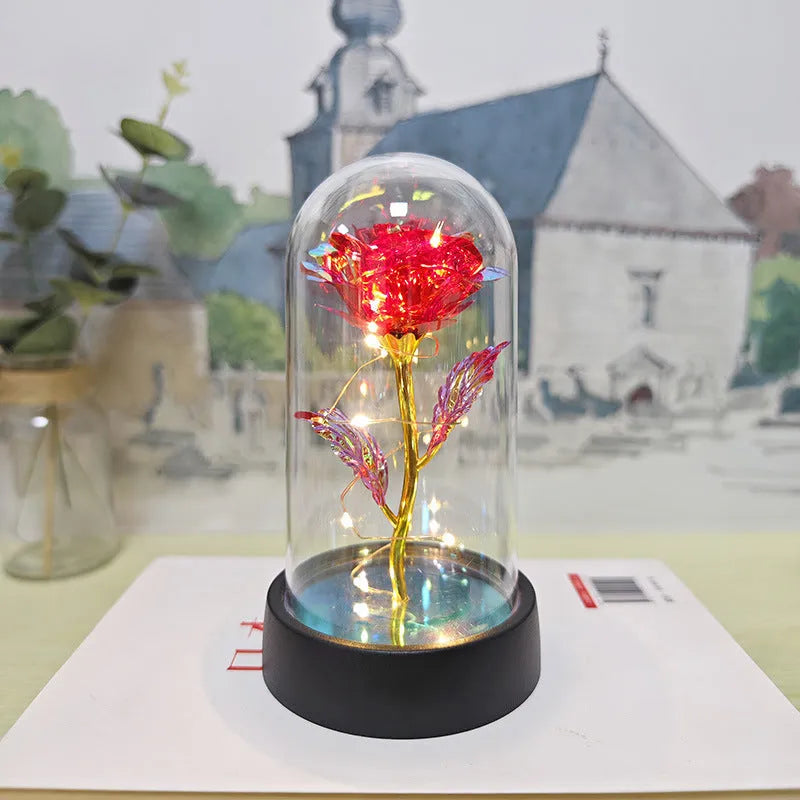 Small decorative night lamp with glass cover, plastic flower, and black base on a pink box.