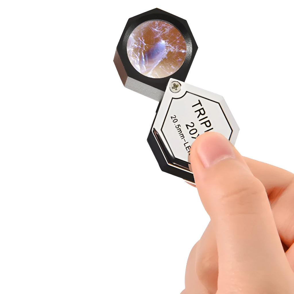 Handheld portable magnifying glass for jewellery and coin inspection with metal frame.
