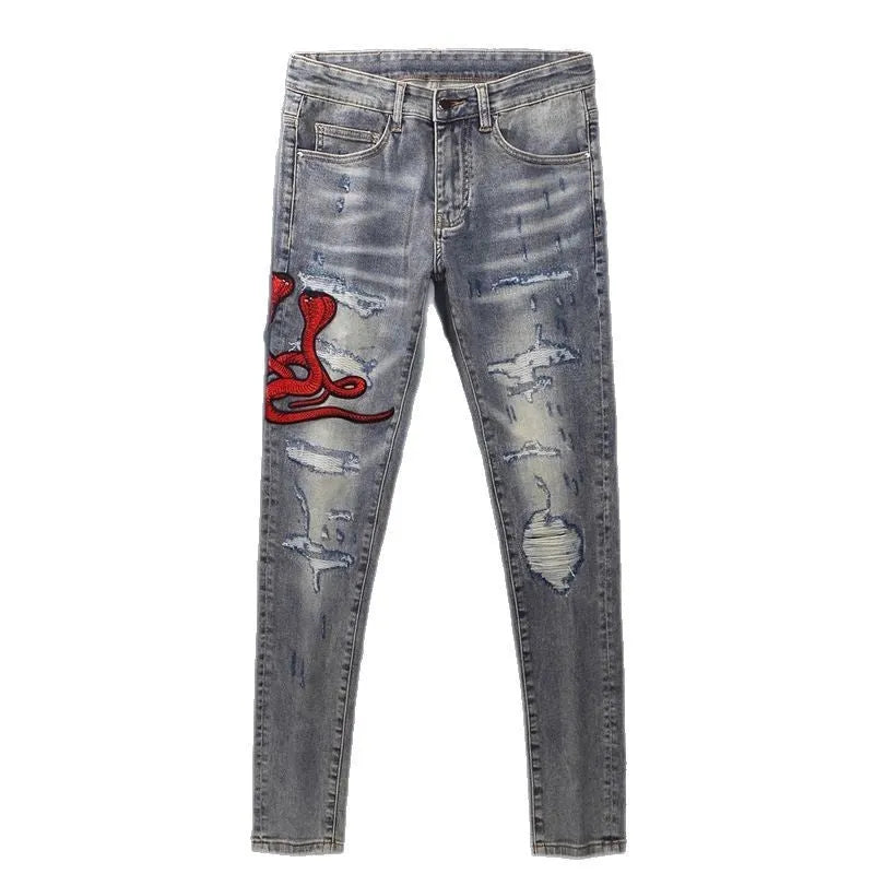 Distressed slim fit jeans with embroidered hole patches in washed-out old colour