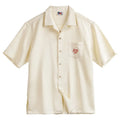 Light apricot men's shirt with bamboo and flower pattern and a Cuban collar.