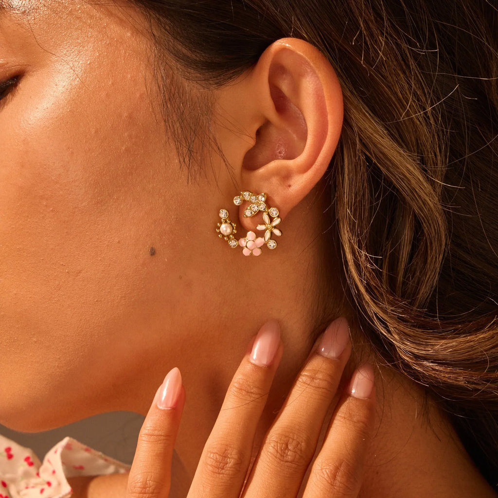 Close-up of colourful oil finish flower-shaped stud earrings with petal details on a stainless steel post.