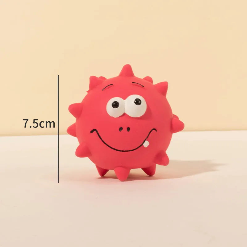 Set of four coloured latex squeaky dog balls with cute faces on a bumpy surface.