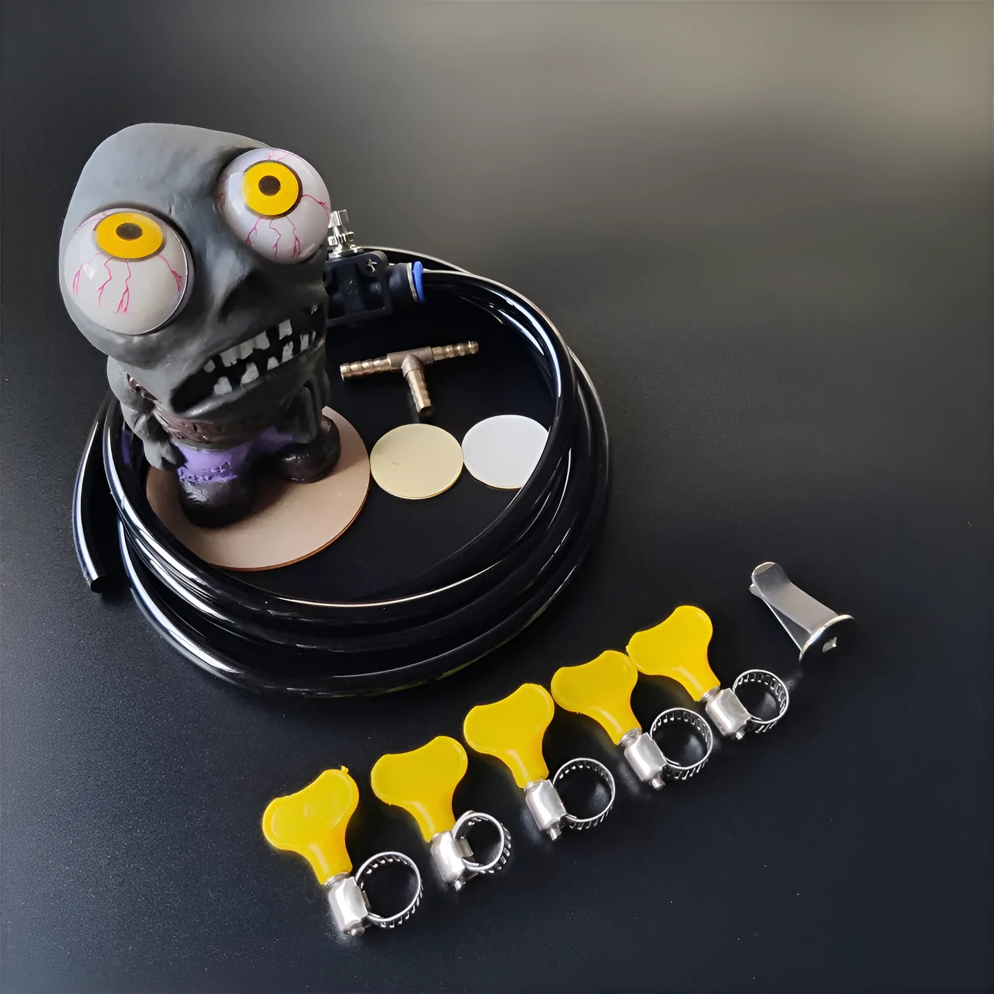 Turbo car Explosive Eye Doll ornament kit with pressure valve, copper tube, and mounting clip on a car dashboard vent.