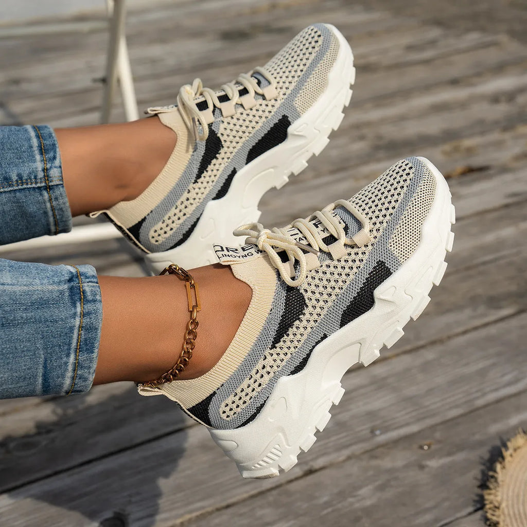 Women's lace-up Flyknit mesh sneakers in a grey colour combination with a round toe and flat rubber sole.