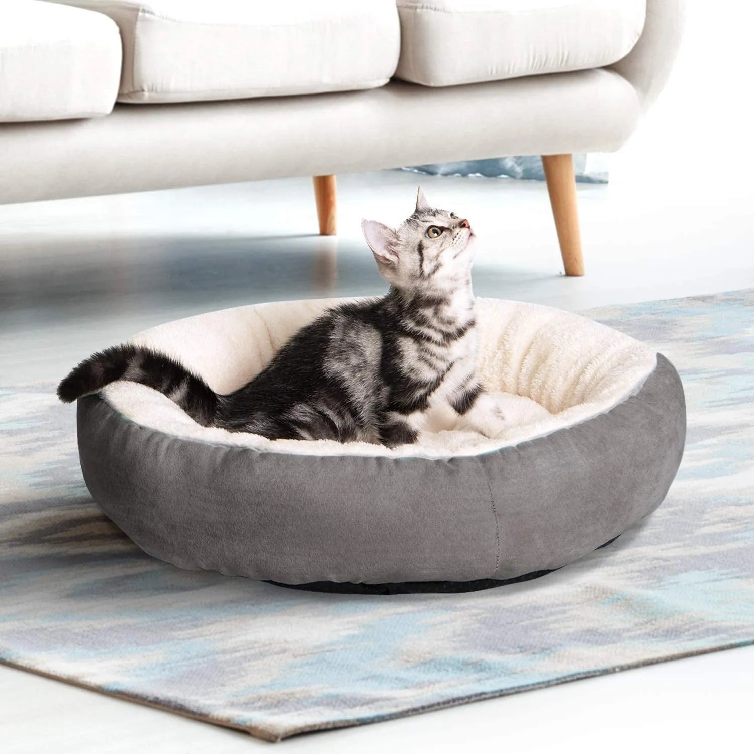 Circular warm soft pet nest dog bed in gray cloth with raised rim, size S, on a wooden floor