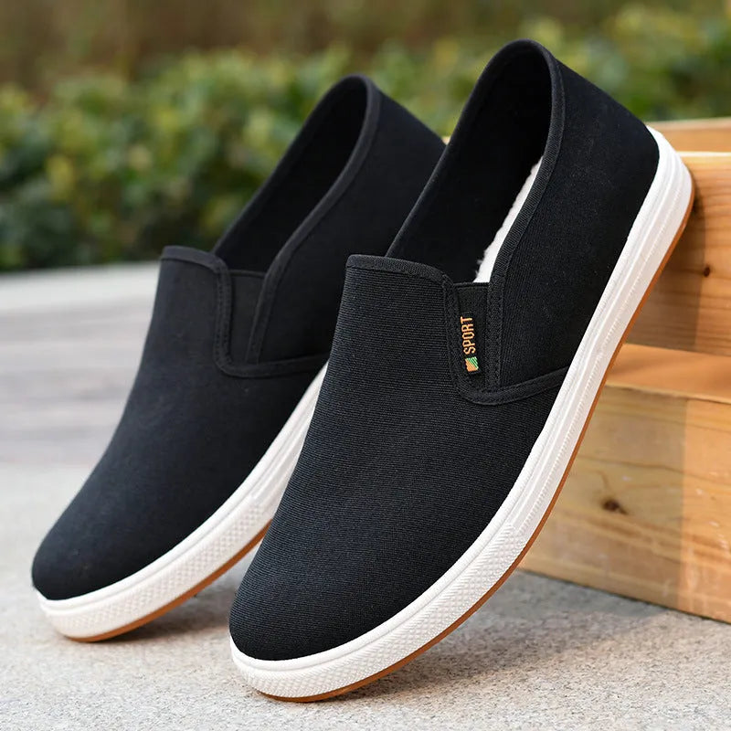 Men's black and blue slip-on canvas shoes with composite soles showing round toe design