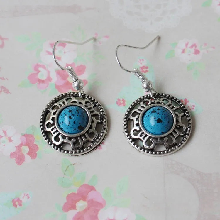 Handmade geometric flower disk earrings in Tibetan silver and turquoise with ethnic Miao design.