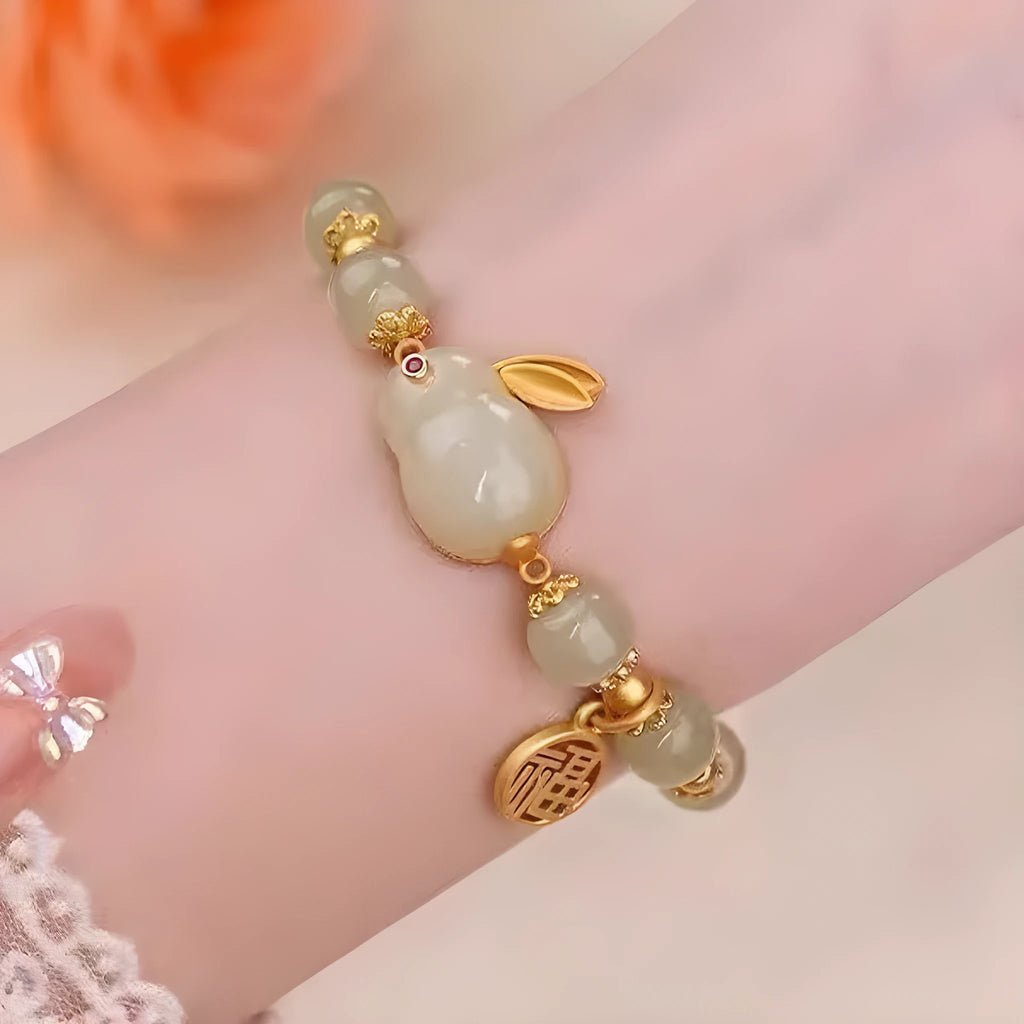 Green jade hare charm bracelet with black hand band showing lily engravings and fu character detail