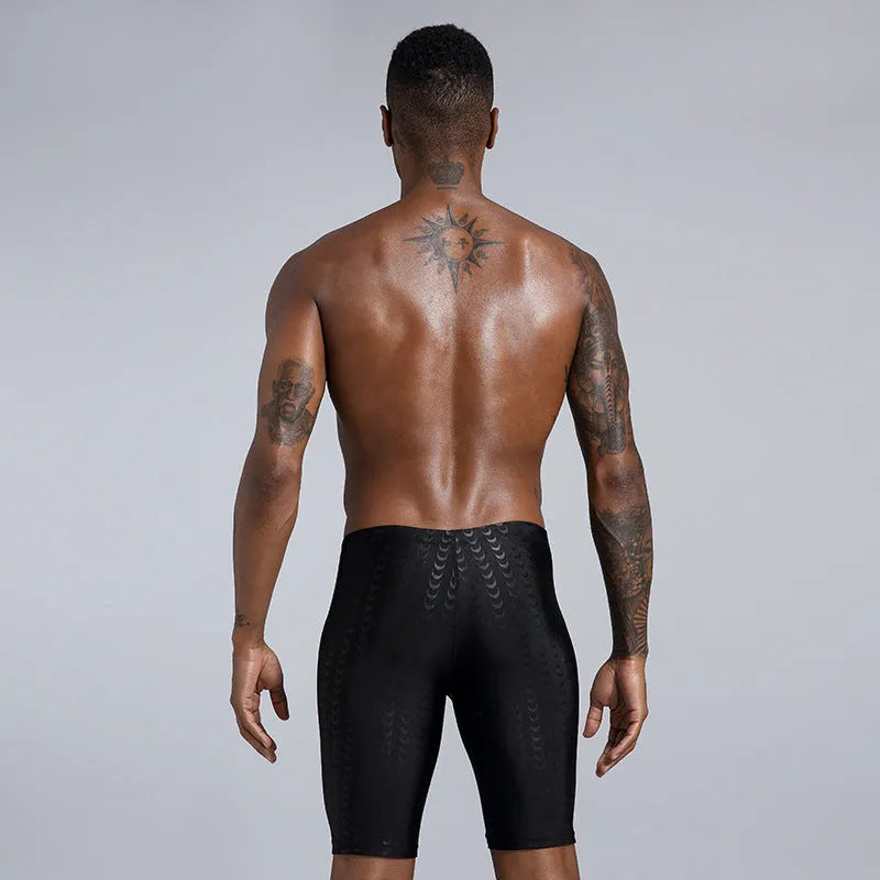 Men's solid colour waterproof shark skin fabric swimming trunks in pool setting