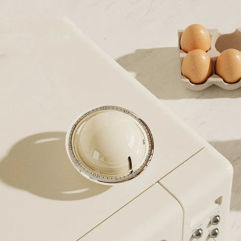 Beige mechanical kitchen timer with manual twist dial and countdown display on a kitchen countertop