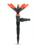 Automatic rotating garden sprinkler in orange plastic, size 14x26.5cm, on green lawn