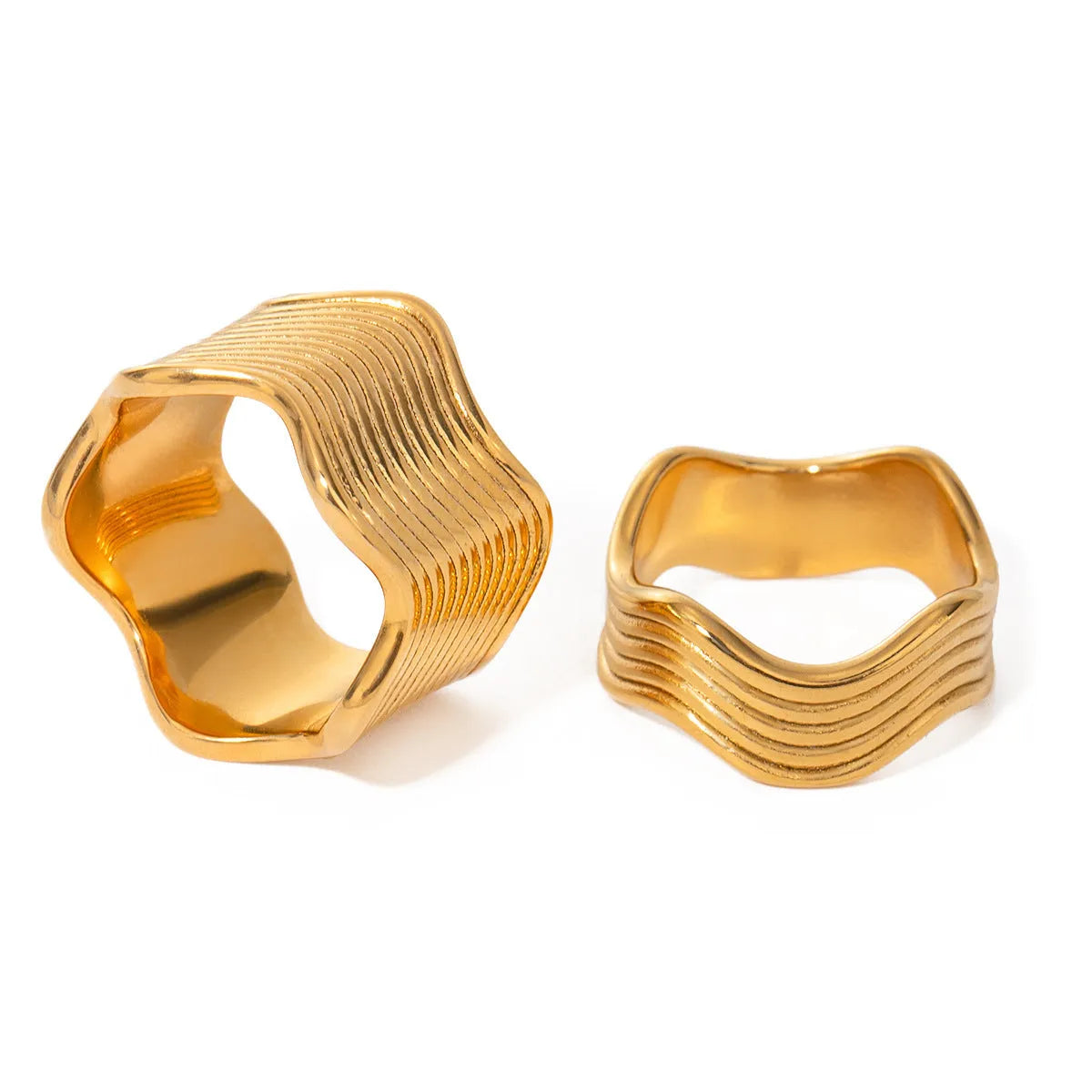 Close-up of a stainless steel ring with a wide geometric wave pattern and electroplated metallic finish.