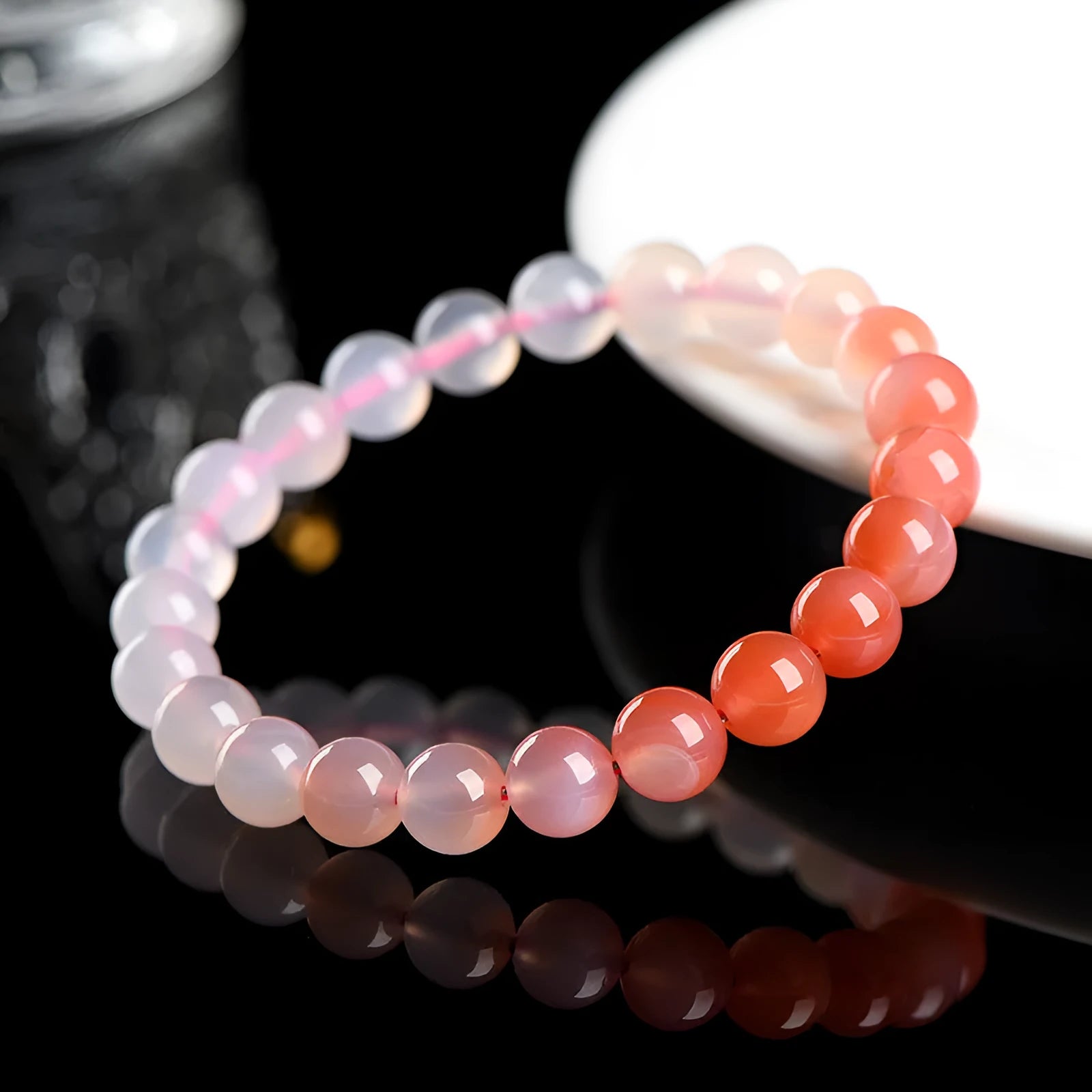 A gradient colour agate bead bracelet on a wrist, showing natural stone banding.